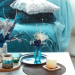 Modern living room, with artificial flowers in a vase and home decor items on a wooden light table.